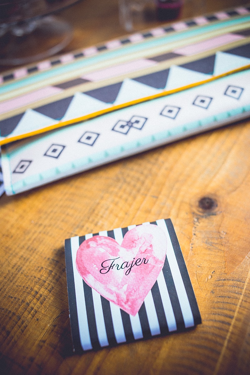 Frajer kartica sa roze srcem i šarena torbica na drvenom stolu