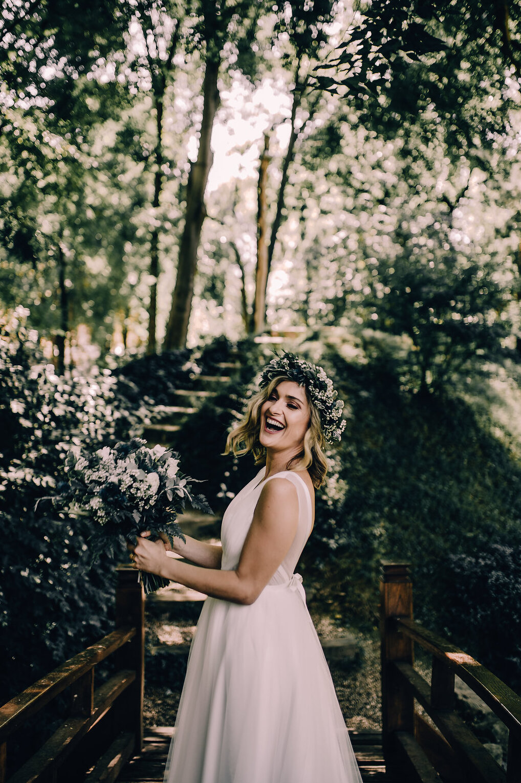 Mlada se smeje sa buketom u šumi