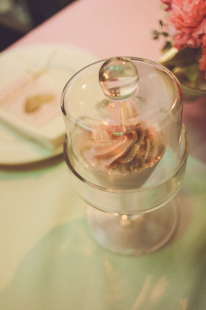 Roze flamingo figura na stolu sa roze cvetnim aranžmanom