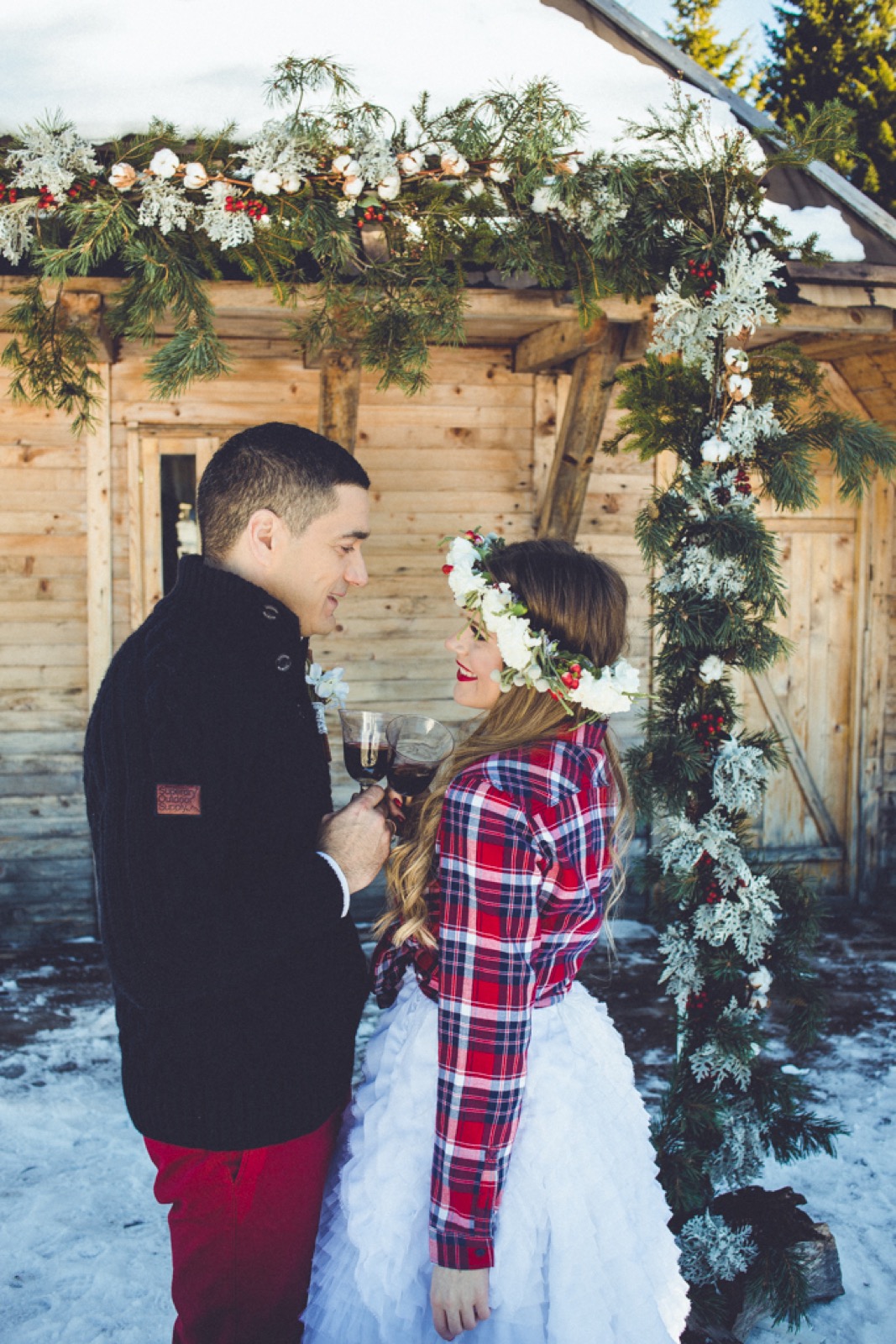 Par se drži za ruke pod venčanim lukom od zelenja