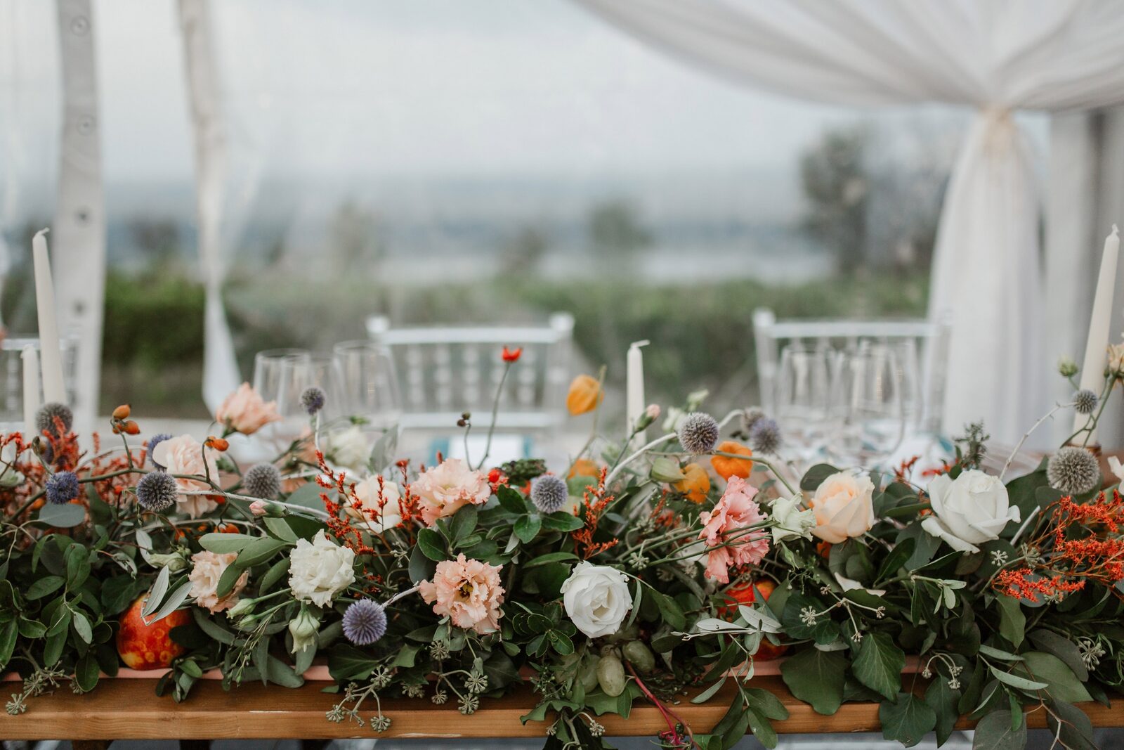 Bogat cvetni aranžman — ruže boje kajsije, bele ruže, plavičasti čičak
